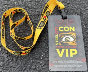 A Steel City Con VIP badge and yellow lanyard from August 2022, showing the convention logo and VIP pass details.